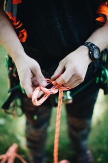 a man hand tying a rope